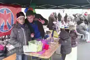 Unser Infostand mit Buttonmaschine und Bastelequipment. Im Hintergrund eine Falkenfahne